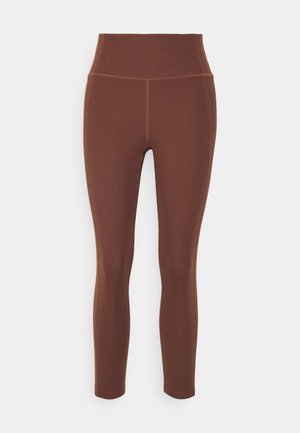 Bruine hooggerokte leggings van een gladde, rekbare stof. Bevat platte naden en een aansluitend ontwerp voor comfort en flexibiliteit.