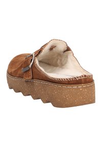 Brown suede slip-on shoe with a fuzzy interior, featuring a decorative buckle and a chunky cork sole with a zigzag pattern.