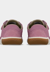 Chaussures en daim rose à texture lisse, dotées d'une semelle en caoutchouc blanche et d'une semelle extérieure marron à motifs, maintenues par des sangles ajustables.