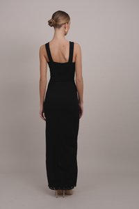 Black, form-fitting dress with wide straps, open back, and a lace-trimmed hem. Crafted from smooth fabric, it features a rear zipper closure.