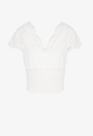 Top court en dentelle blanche avec un décolleté V plongeant, des manches courtes et légères, et un ourlet festonné. Le tissu arbore un motif floral et une surface texturée.