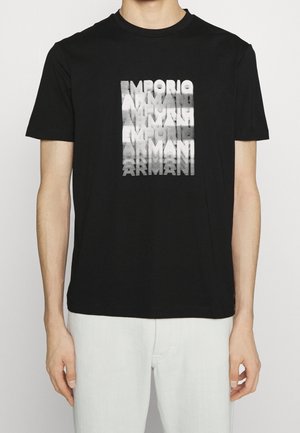 Czarny bawełniany T-shirt z grafiką i napisem „Emporio Armani” w efekcie gradientu. Krótkie rękawy i okrągły dekolt.