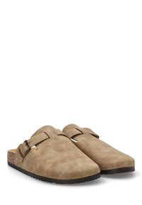 Zuecos de ante beige sin cierre, con plantilla de corcho, punta redondeada y acento de hebilla de latón. Superficie texturizada, suela plana, diseño de talón abierto.