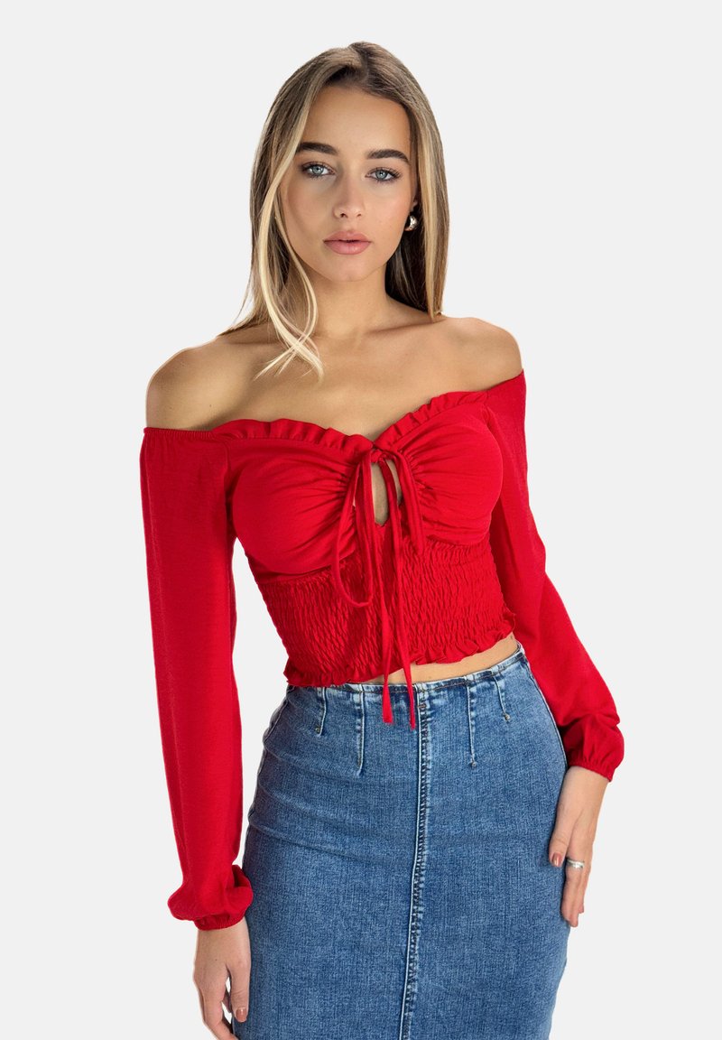 Rød off-shoulder top med rynket halskant og bindedetalje, struktureret smocket talje, lange ærmer. Parret med blå denim blyantskørt.