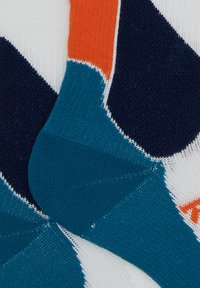 Calzini multicolori nelle tonalità di verde acqua, blu navy, arancione e bianco; con un motivo geometrico caratterizzato da blocchi di colore distinti e texture variabili.