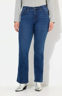 Tummansiniset farkut suoranlahkeisella leikkuulla, etutaskuilla ja nappikiinnityksellä. Yhdistetty kiiltäviin hopeisiin nilkkasaappaisiin.