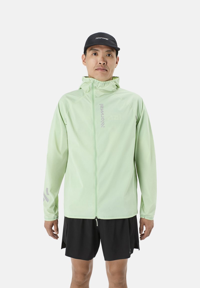 Hellgrüne, leichte Reißverschlussjacke mit Kapuze, reflektierenden Akzenten und glatter Textur, getragen über schwarzen Shorts.