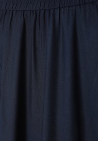 Navyblauer Rock aus einem strukturierten Stoff. Verfügt über einen elastischen Taillenbund und ein fließendes Design, das eine weiche, legere Silhouette schafft.