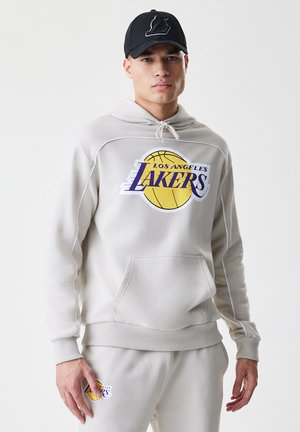 Hoodie cinza claro com bolso frontal, punhos e bainha canelados. Apresenta um grande logotipo "Lakers" em roxo e amarelo. Combinado com calças de moletom correspondentes.