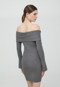 Abito grigio a coste con scollo all'americana, maniche lunghe, forma aderente e lunghezza fino a metà coscia. Tessuto morbido con dettagli minimi.