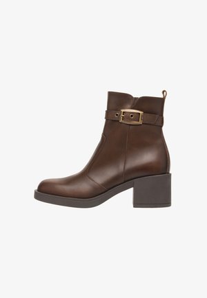 Brown leather ankle boot with a square toe, wide mid-heel, side zipper, and a decorative strap featuring a gold buckle detail.