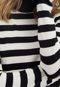 Schwarz-weiß gestreifter Rollkragenpullover mit weicher Textur. Verfügt über wechselnde breite und schmale Streifen, enganliegende Ärmel und einen hohen Kragen.