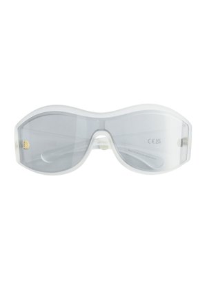 Lunettes de soleil surdimensionnées à monture blanche avec verres gris clair, pont large et détail discret de charnière dorée sur un fond blanc uni.