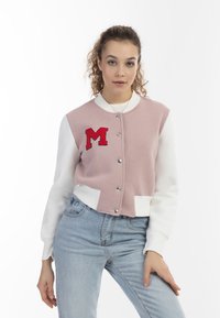 Rosa-weiße, kurz geschnittene Collegejacke mit silbernen Druckknöpfen und einem gestickten roten "M" auf der Brust. Weicher Stoff mit gerippten Bündchen.