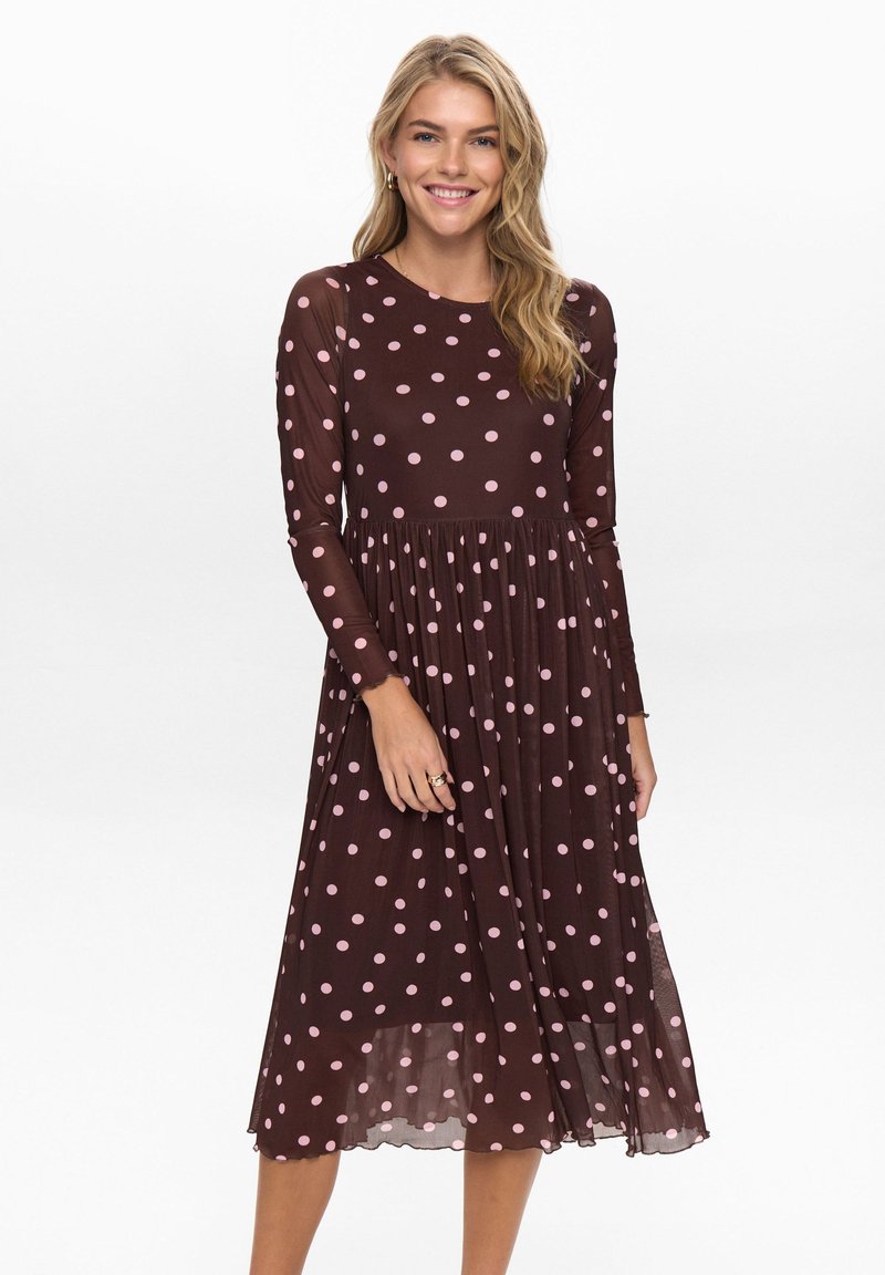 Robe marron à manches longues avec des pois roses, design fluide, encolure ronde et jupe plissée ; tissu léger et transparent.