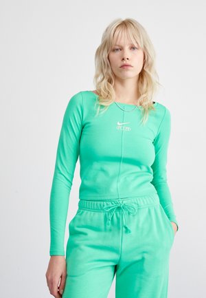 Long-sleeve, mint green top with a round neckline and logo, paired with matching joggers featuring an elastic waistband and side pockets.