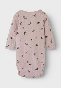 Combinaison tricotée rose avec des manches longues, un col rond et une broderie florale éparpillée. Texture douce avec un motif côtelé fin sur l'ensemble.