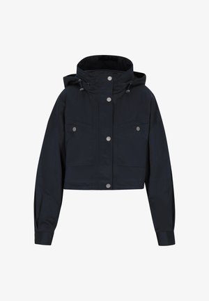 Zkrátená tmavomodrá bunda vyrobená z odolného materiálu. Má kapucňu, strieborné cvočky a dve predné vrecká. Hladký povrch.