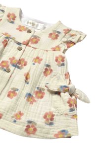 Vestido de tejido crema con estampado floral en tonos rosa, amarillo y azul. Cuenta con un escote redondo, cierre de botones y detalle de lazo en la cintura.