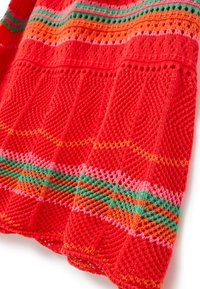 Roter Strickstoff mit strukturiertem Muster, das leuchtende horizontale Streifen in Grün, Orange und Pink aufweist.