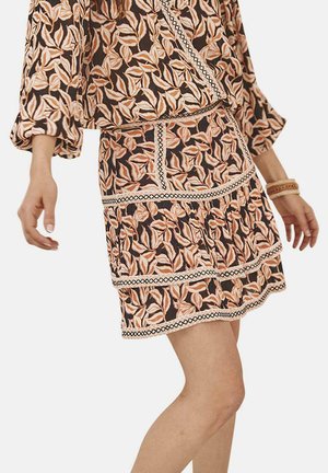 Vestido con estampado floral sobre un fondo oscuro, con diseños de hojas en rosa y naranja, falda acampanada y detalles de ribete en contraste.