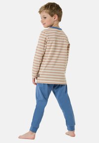 Striped long-sleeve top in beige and cream with blue accents, paired with blue pajama pants. Soft fabric, slim fit, elastic cuffs.