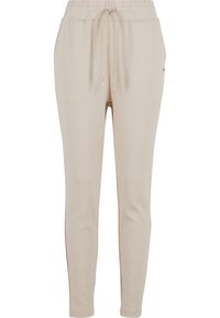Beige Jogginghose mit elastischem Bund und Kordelzug, mit glatter Textur und schmal zulaufendem Bein-Design. Minimales Branding-Detail.