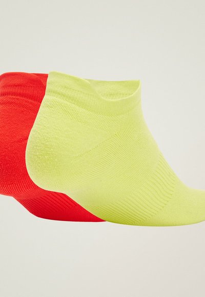 Dos pares de calcetines tobilleros: uno rojo brillante y uno amarillo fluorescente. Ambos presentan una textura acanalada y un diseño sin costuras.