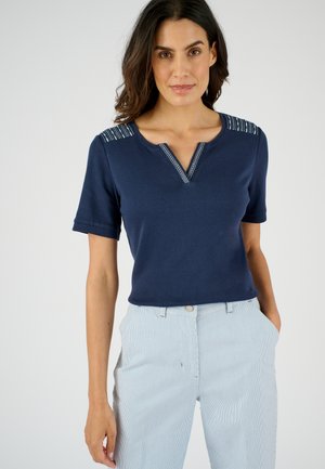 Navyblauw T-shirt met korte mouwen en een V-hals, voorzien van gestreepte details op de schouders, gemaakt van gladde stof, gecombineerd met lichtgestreepte broeken.