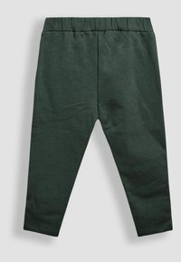 Leggings de algodón verde oscuro con cinturilla elástica, ajuste ceñido y textura suave. Sin patrones visibles ni detalles de hardware.