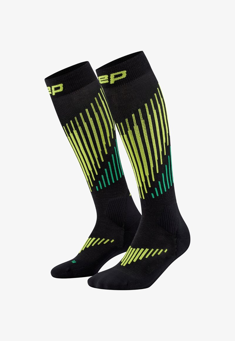 Schwarze knielange Sportsocken mit vertikalen Streifenmustern in Gelb und Grün sowie gepolstertem Fußdesign.