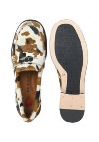 Bruine en witte gespotte schoenen met een zachte, bontachtige bovenkant, zwarte randen en een rubberen zool met zichtbare branding en een hartvormige accent.