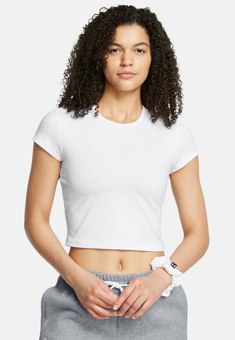 Witte cropped t-shirt met korte mouwen, mooie textuur, ronde halslijn, gedragen met grijze joggingsbroek. Geen patronen of zichtbare accenten.