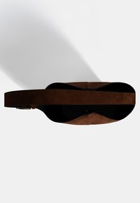 Braune Wildleder-Handtasche mit runder Form, ausgestattet mit einem breiten Trageriemen und kontrastierendem schwarzen Innenraum. Geschmeidige Textur mit minimalen Hardware-Details.