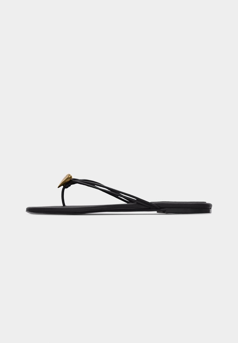Μαύρο επίπεδο σανδάλι τύπου σαγιονάρα με πολλούς λεπτούς ιμάντες και μικρή χρυσή διακόσμηση σε σχήμα σταγόνας στη μπροστινή λωρίδα.