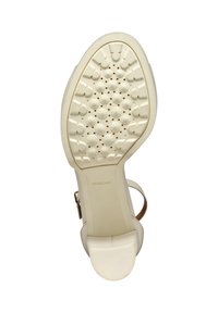 Vit gummisula med ett strukturerat greppmönster, med cirkulära och stjärnformade indragningar, samt en sleek, kurvad häldesign.