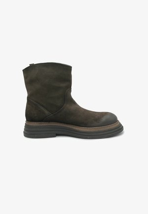 Stivaletto in suede marrone con punta arrotondata, dettagli cuciti e suola in gomma testurizzata. Presenta un tacco basso impilato.