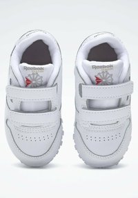Hvite Reebok klassiske sneakers med borrelås, rund tå, perforert detaljer, polstret innvendig og teksturerte gummisåler.
