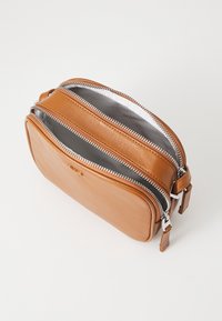 Borsa in pelle marrone chiaro con due chiusure a zip silver, forma rettangolare e interno foderato con un motivo a righe. Gli accessori includono una tracolla laterale.