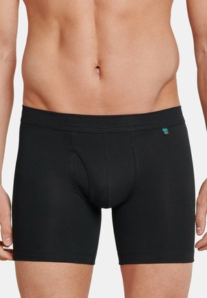 Zwarte boxershorts van zacht, rekbaar materiaal. Beschikt over een aansluitend ontwerp, een elastische tailleband en een gevormde pouch voor ondersteuning.