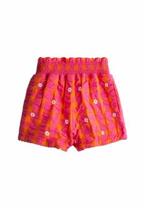 Pink og orange ternede shorts med en smocket linning og små hvide blomstermønstre spredt over stoffet.