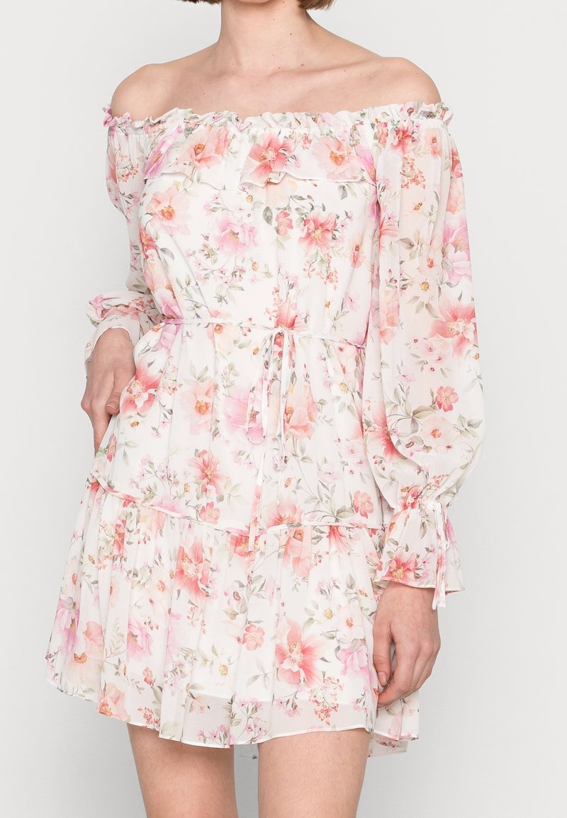 Axelklädd blommig klänning med långa, manschettärmar. Lätt tyg, volangkant och midja med resår där lager av volanger pryder klänningen, med rosa och gröna mönster.