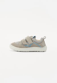 Grå semsket sneakers med nettdetaljer, to justerbare borrelåsremmer, blå aksenter på sidene og en gummi såle.