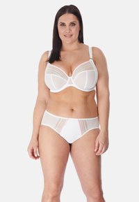 Witte lingerie set met een doorschijnende bralette met stippenaccenten en bijpassende hooglijn briefs met contrasterende details.