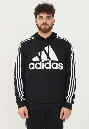 Felpa nera con cappuccio, logo Adidas bianco e tre strisce bianche sulle maniche. Realizzata in tessuto morbido con una tasca frontale.