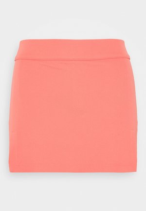Jupe droite rose corail avec une large ceinture et des contours subtils de poches, présentée sur un fond uni gris clair.