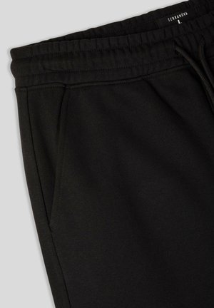 Pantaloni da jogging neri realizzati in morbido misto cotone. Presentano un'elastico in vita, tasche laterali e un design semplice e pulito.