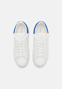 Hvite sneakers med blå detaljer, med en glatt lær-overdel, flate lisser og en polstret såle. Merking synlig på tungen.