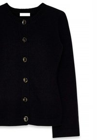 Melna kardigāns, kas izgatavots no mīksta adīta auduma, ar ribotu apaļu kaklu, septiņiem spīdīgiem pogām priekšpusē un ribotām aprocēm uz piedurknēm.
