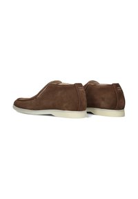 Chaussures à enfiler en suede marron avec une surface lisse et un bout arrondi, présentant une semelle en caoutchouc texturée et de subtils accents de couture.